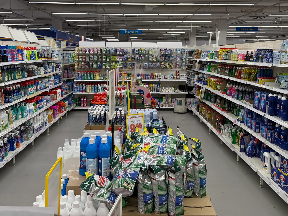 Pesuainekäytävä: yleispuhdistusaineet, astianpesuaineet ja konetiskiaineet hyllyissä